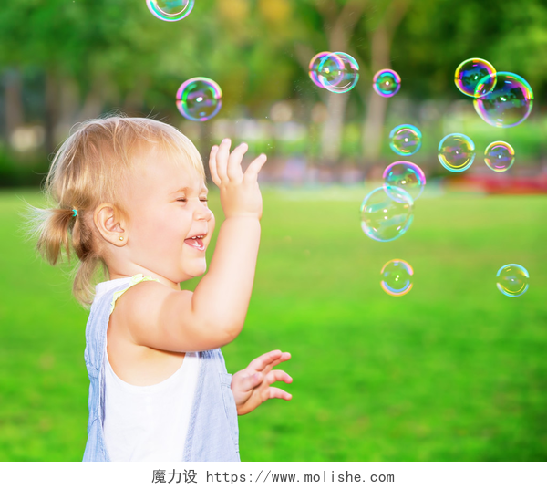 金发女孩在公园吹泡泡快乐的孩子在户外玩
